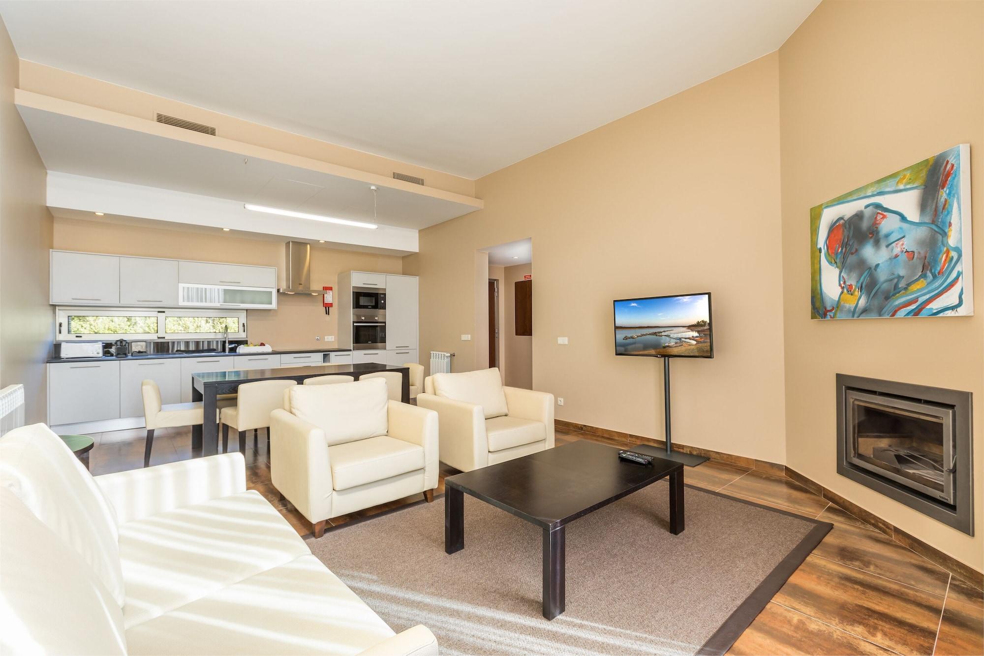 Ap Lago Montargil - Conference & Spa מראה חיצוני תמונה The photo shows a modern, spacious living area with a contemporary design. The room features light-colored walls and wooden flooring. 

In the center, there is a black coffee table surrounded by four white armchairs. A flat-screen TV is mounted on th